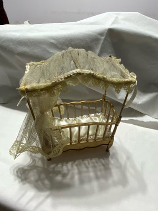 Cuna de muñecas dorada con dosel
