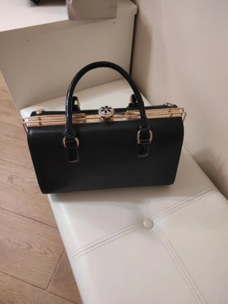 Bolso de mano negro con detalles dorados