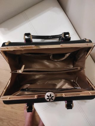 Bolso de mano negro con detalles dorados