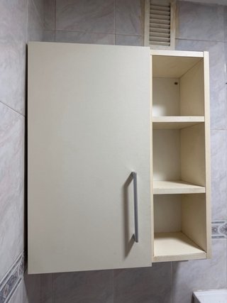 Mueble de baño blanco con puerta y estantes