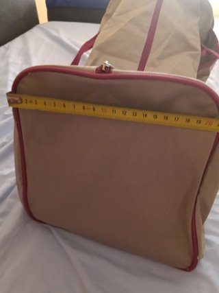 Bolso de viaje beige con detalles rosas