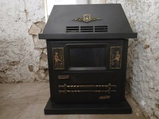 Estufa de gasoil vintage negra con detalles dorado