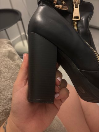 Botines de tacón negros con cremallera dorada.