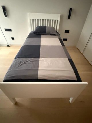 Cama individual blanca con cabecero