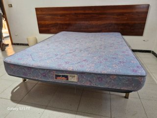 Cama con colchón y cabezal de madera
