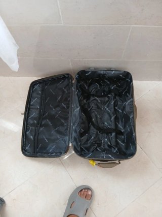 Maleta de viaje marrón con detalles naranjas