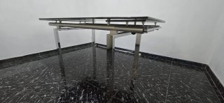 Mesa de cristal y acero, extensible,con sillas.