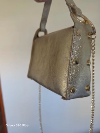 Bolso de mano dorado con cadena