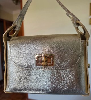 Bolso de mano dorado con cadena