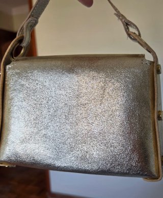 Bolso de mano dorado con cadena