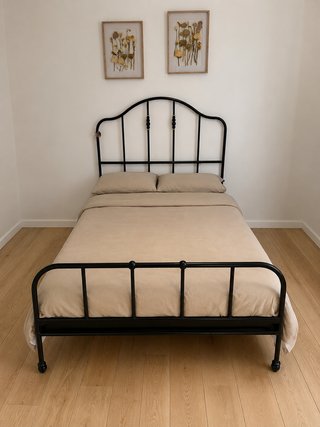 Cama de metal negra con cabecero curvo