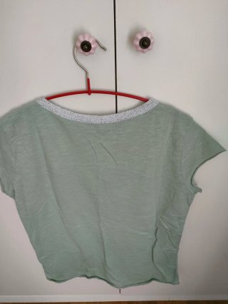 Camiseta verde con escote pico y detalle plateado