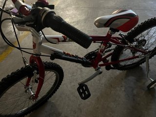 Bicicleta infantil roja con ruedines