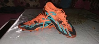 Botas de fútbol naranjas y azules