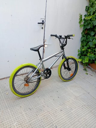 Bici BMX plateada con ruedas amarillas