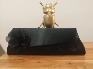 Cartera de fiesta negro con flor.
