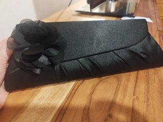 Cartera de fiesta negro con flor.