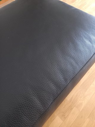 Pouf in pelle nera con gambe metalliche