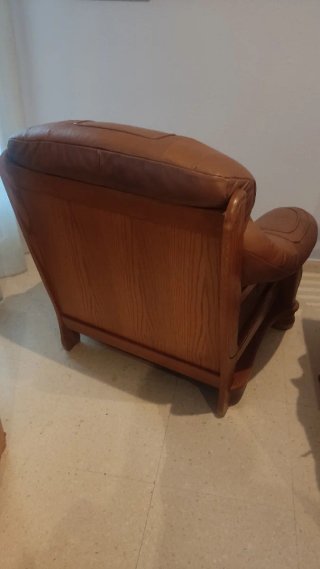 Sofá de piel marrón con detalles de madera
