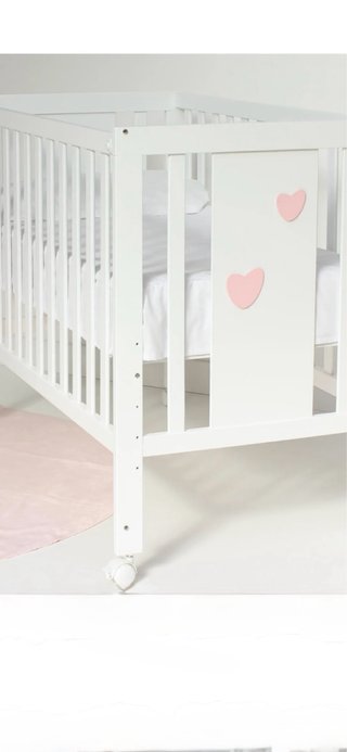 Cuna blanca con corazones rosas