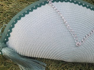 Bolso de mano verde con cadena plateada