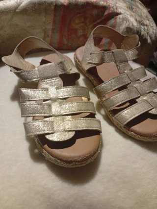 Sandalias doradas estilo gladiador y otra