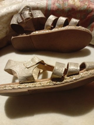 Sandalias doradas estilo gladiador y otra