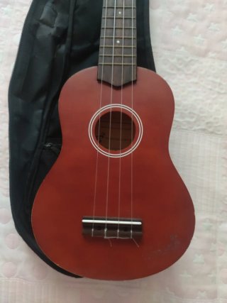 Ukelele rojo con funda negra