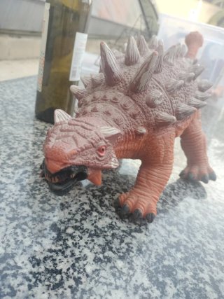 Dinosaurio de juguete marrón