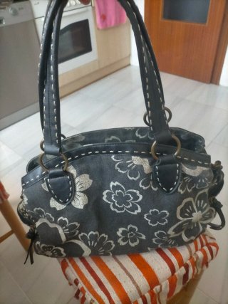 Bolso de mano gris con flores blancas