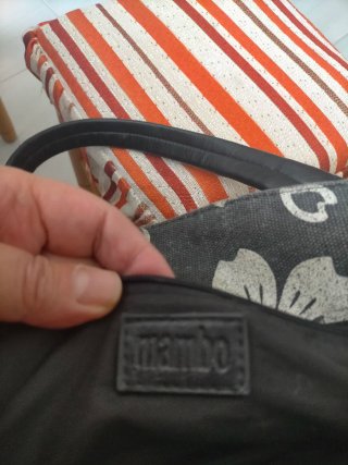 Bolso de mano gris con flores blancas