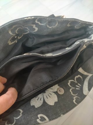 Bolso de mano gris con flores blancas