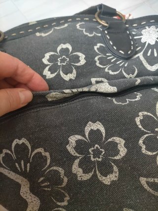 Bolso de mano gris con flores blancas