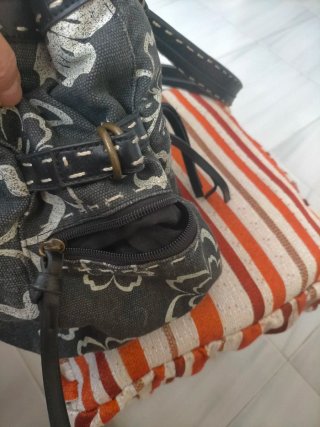 Bolso de mano gris con flores blancas