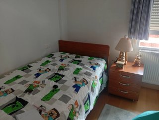 Cama individual de madera con colchón y mesilla