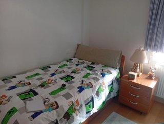 Cama individual de madera con colchón y mesilla