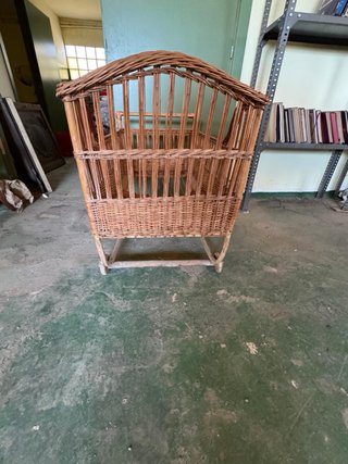 Cuna de mimbre con ruedas de madera