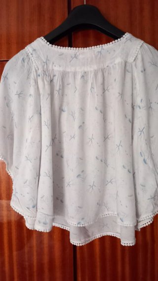 Blusa blanca con estampado floral azul. T 16 años