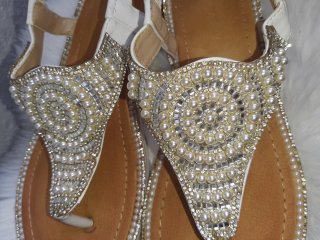 Sandalias blancas adornadas con perlas y pedrería