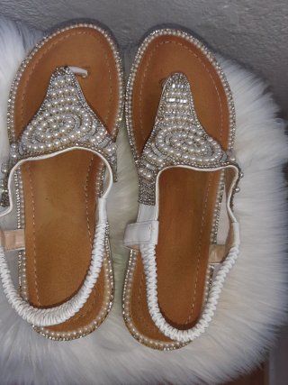Sandalias blancas adornadas con perlas y pedrería