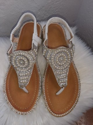 Sandalias blancas adornadas con perlas y pedrería