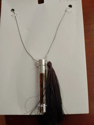 Collar Zara tubo metálico con piedra y pompón