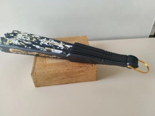 Abanico negro con gancho dorado dibujos blancos y