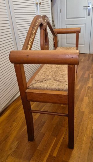 Banco de madera artesanal con cojines de cuadros.