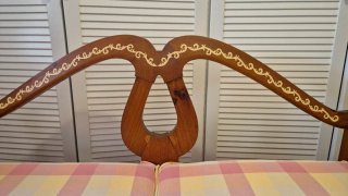 Banco de madera artesanal con cojines de cuadros.