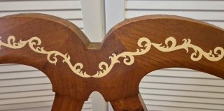 Banco de madera artesanal con cojines de cuadros.