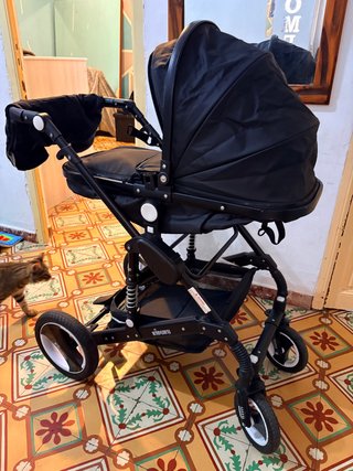 Carro de bebé negro con silla de coche y capazo