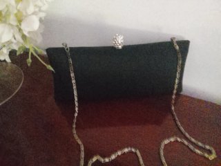 Cartera de mano negra con cadena plateada