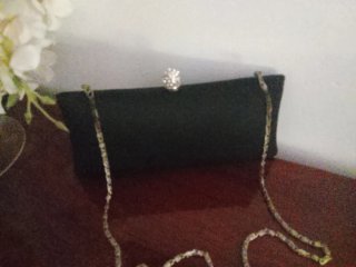 Cartera de mano negra con cadena plateada