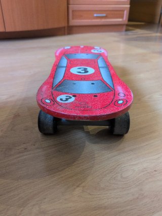 Monopatín Oxelo rojo con diseño de coche.